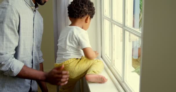 Vista Lateral Jovem Pai Negro Brincando Com Seu Filho Peitoril — Vídeo de Stock