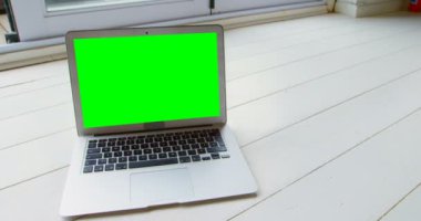 Dizüstü evde ahşap zemin üzerinde Close-Up. Yeşil ekran laptop 4k