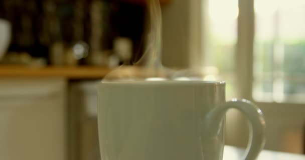 편안한 부엌에 식탁에 커피의 클로즈업 나오는 커피잔 — 비디오