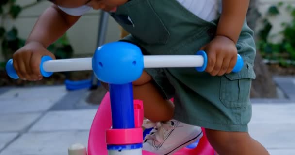 Primer Plano Lindo Niño Negro Jugando Con Triciclo Patio Trasero — Vídeos de Stock