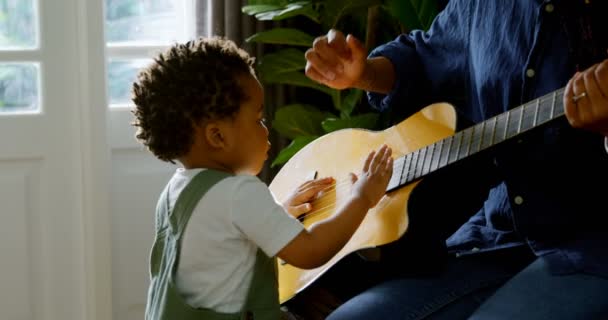 Vista Lateral Joven Madre Negra Pequeño Hijo Tocando Guitarra Sala — Vídeo de stock