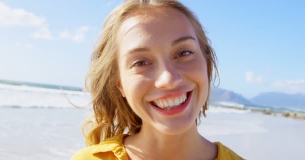 站在海滩上的年轻白人妇女的前面 她面带微笑 看着4K — 图库视频影像
