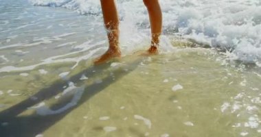 Kumsalda yürüyen kadın düşük bölümü. O çıplak ayakla buzlu 4 k yürüyor