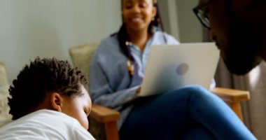 Genç siyah babası oğlunun yaşam rahat ev ile oynarken close-up. Kanepede oturan ve oğlu 4 k seyir dizüstü bilgisayar ile anne