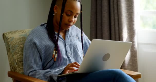 在舒适的家中工作的年轻黑人妇女的前面 她坐在沙发上4K — 图库视频影像