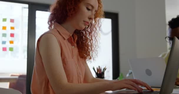 年轻的高加索女商人在现代办公室的笔记本电脑工作的侧视图 她正坐在4K — 图库视频影像