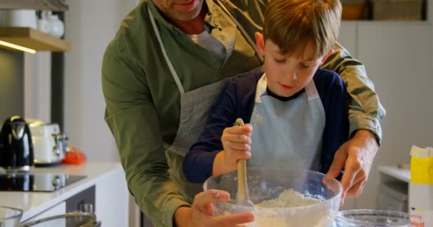 前面的成人白种人父亲和儿子烤饼干在舒适的家的厨房 他们在4K 碗里混合面粉 — 图库视频影像