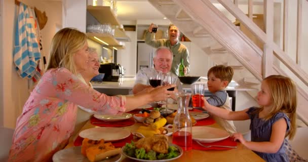 高加索多代家庭在家里的餐桌上敬酒一杯饮料 愉快的多代家庭坐在餐桌4K — 图库视频影像