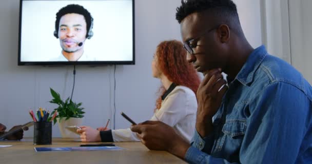在办公室里进行年轻的混血商业团队规划和视频会议通话的侧视图 他们正在讨论和使用4K 多媒体设备 — 图库视频影像