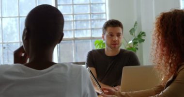 Genç takım karışık ırk iş planlaması ve modern ofis kafeteryada oturan serin. Etkileşim ve çoklu ortam aygıtı 4 k kullanma