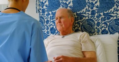 Arkadan görünüş genç Kafkas kadın doktor ilaç komuta sizde ile evde yatakta tartışıyor. Yatakta yatarken ve su 4 k tutan komuta sizde