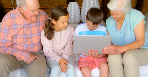 在舒适的家中使用笔记本电脑的多代高加索家庭的正面视图 他们坐在沙发上4K — 图库视频影像