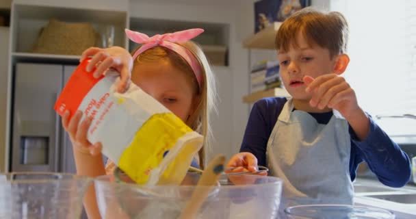 前面的可爱的高加索兄弟姐妹烤饼干在舒适的家的厨房 他们正在用筛子4K 筛选面粉 — 图库视频影像