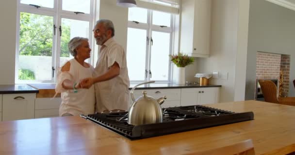 在舒适的家中 高级黑人夫妇在厨房里一起跳舞的侧视图 他们面带微笑 手牵着手4K — 图库视频影像
