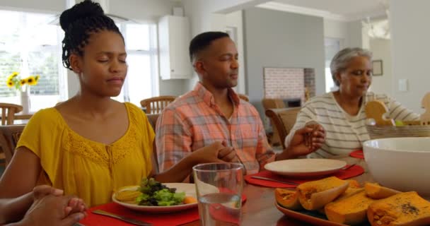 黑人家庭在舒适的家中的餐桌上一起祈祷的正面景色 他们闭上眼睛 手牵着4K — 图库视频影像