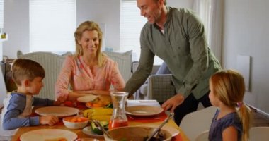 Genç Beyaz aile rahat bir ev yemek masasında yemek önden görünümü. Birlikte 4 k için dua ediyor