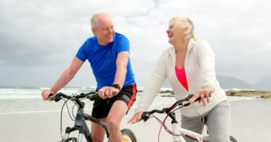 Yaşlı çift binicilik bisiklet Plajı'nda önden görünümü. Yaşlı çift gülümseyen ve 4 k birbirine bakarak