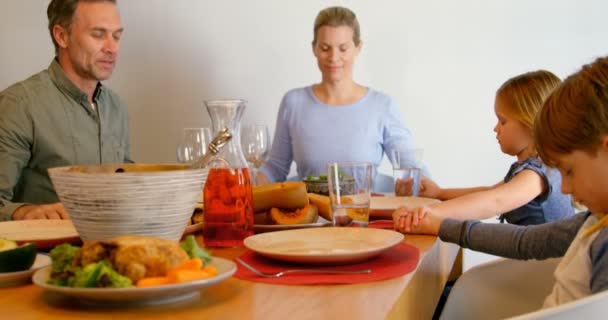 白种人一家在舒适的家中在餐桌上一起祈祷的正面景色 他们闭上眼睛 手牵着4K — 图库视频影像