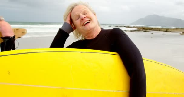 Vista Frontal Una Vieja Mujer Caucásica Sosteniendo Tabla Surf Playa — Vídeo de stock