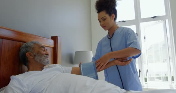 年轻混血女医生检查家中老年男子血压的正面看法 她用的是血压计4K — 图库视频影像