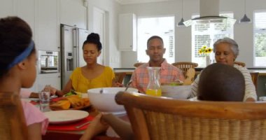 Çok siyah kuşak aile birlikte rahat evinde yemek masasında dua önden görünümü. Gözleri kapalı ve elleri 4 k holding olduklarını
