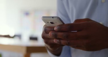 Smartphone cep telefonu ile modern bir ofiste çalışan genç siyah işadamı close-up. O da 4 k metindir manifatura