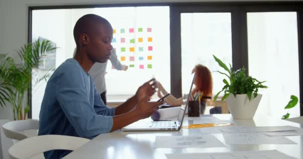 Yan Masada Oturan Smartphone Üzerinde Çalışan Genç Siyah Işkadını Görünüm — Stok video