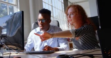 Planlama ve modern ofiste masaüstü pc üzerinde çalışan genç karışık ırk iş takım önden görünümü. Onlar bilgisayar 4 k görüşüyorlar