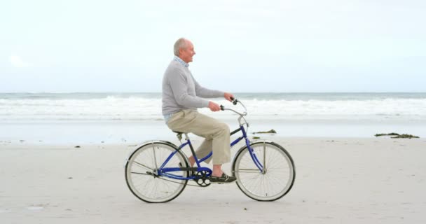 Vista Laterale Del Vecchio Uomo Anziano Caucasico Bicicletta Sulla Spiaggia — Video Stock