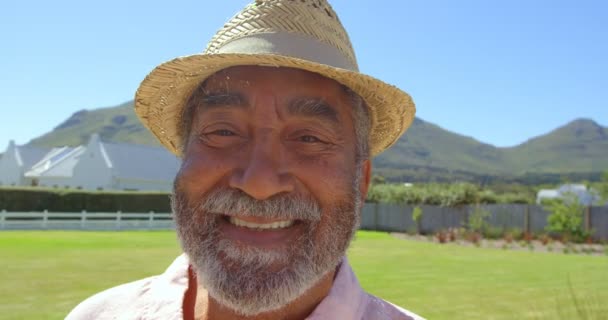 シニアの黒人男性の家の裏庭で晴れた日にカメラ目線の正面 彼は幸せと楽観的な — ストック動画
