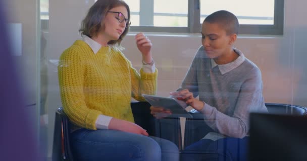 若い白人女性幹部は近代的なオフィスにデジタル タブレット上を議論します デジタル タブレットを保持している若い女性幹部 — ストック動画