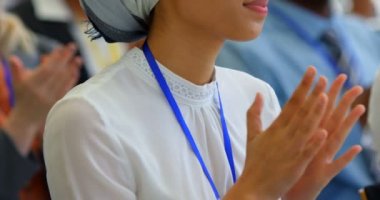 4k iş seminerinde otururken bir konuşma alkışlayan Asyalı bir iş kadını Yan görünümü