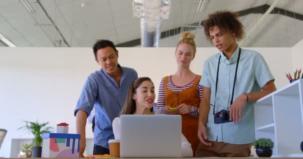 Vue de face de femme d'affaires caucasienne travaillant sur son ordinateur portable interagit avec d'autres hommes d'affaires dans un bureau 4k 