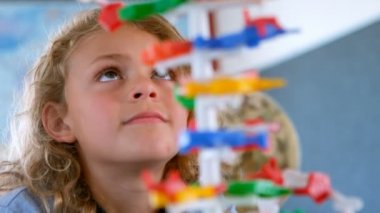 Dna modeli okulda sınıfta okuyan tatlı sarışın beyaz kız öğrenci önden görünümü. O Dna modeli 4 k montaj