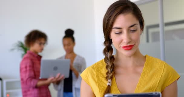 近代的なオフィスにデジタル タブレットを使用してかなり若い白人女性エグゼクティブのフロント ビュー のラップトップ上議論混血人の協力者 — ストック動画