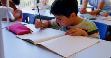 Sınıfta masada güzel Asyalı kadın öğretmen ile etkileşim çeşitli okul çocukları mutlu grubun ön görünümü. Öğrenciler 4k açıklayan öğretmen dinlerken