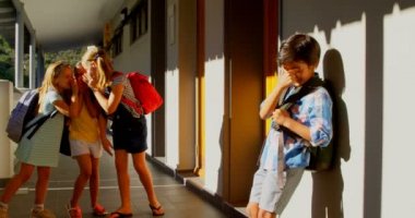 İlköğretim koridorunda üzücü karışık yarış çocuğu zorbalık çeşitli okul çocukları grubun ön görünümü. Koridor 4k ayakta Schoolboy