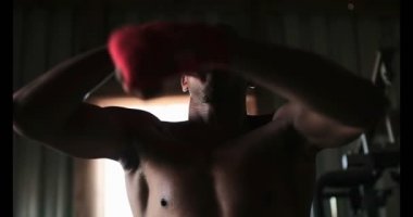 Genç Afro-Amerikan erkek boksör boks fitness salonunda pratik önden görünümü. O kum torbası 4 k vuruyor