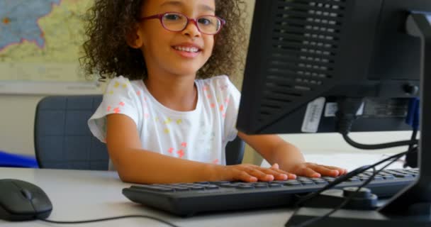 在学校的教室里使用台式电脑的混血女学生的正面看法 她面带微笑 看着4K — 图库视频影像