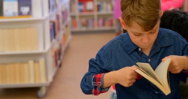 Vista Frontal Estudante Caucasiano Lendo Livro Biblioteca Escolares Selecionando Livro — Vídeo de Stock