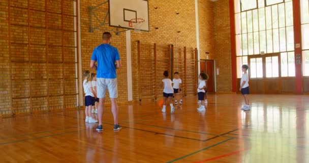 Vista Trasera Del Apuesto Entrenador Baloncesto Masculino Enseñando Baloncesto Los — Vídeos de Stock