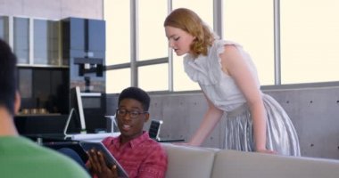 Ofiste dizüstü bilgisayar üzerinden tartışan çok ırklı iş arkadaşlarının ön görünümü. Modern ofiste birlikte çalışıyorlar. 