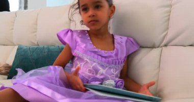 Annesi onu laptop 4 k çalışırken oturma odasında kanepede dijital tablet kullanarak bir Asyalı kızı önden görünümü