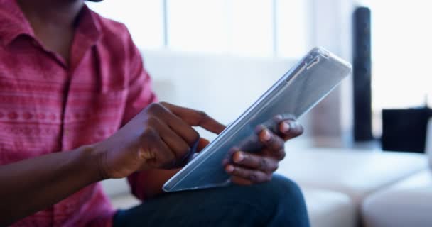 現代のオフィスでデジタルタブレットを使用してハンサムなアフリカ系アメリカ人男性エグゼクティブの側面図 彼はロビーに座っている — ストック動画