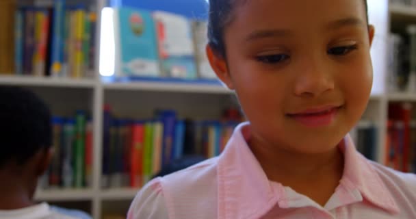站在学校图书馆的快乐可爱的混血女学生的正面看法 她面带微笑 看着4K — 图库视频影像