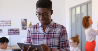 Mutlu handosme Afrikalı Amerikalı erkek yönetici dijital tablet kullanma modern office portresi. O gülümseyen ve kameraya 4 k arıyorsunuz