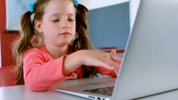 かわいい白人の女子高生の正面図は 机の上に座って 教室でノートパソコンを使用しています 彼女は4K を勉強し 学習している — ストック動画