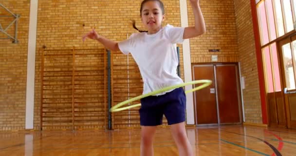 小学校体育館のリングで遊ぶかわいい混血女子高生の正面図 — ストック動画