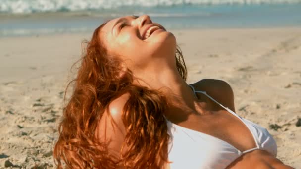 太陽の下 ビーチでビキニを着てリラックスした美しい若い白人女性のフロント ビュー 彼女は笑みを浮かべて を検索 — ストック動画
