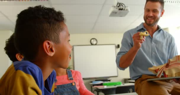 学校で教室で解剖模型を説明する成人白人男性教師の正面図 彼に聞いた学校の子供たち4K — ストック動画